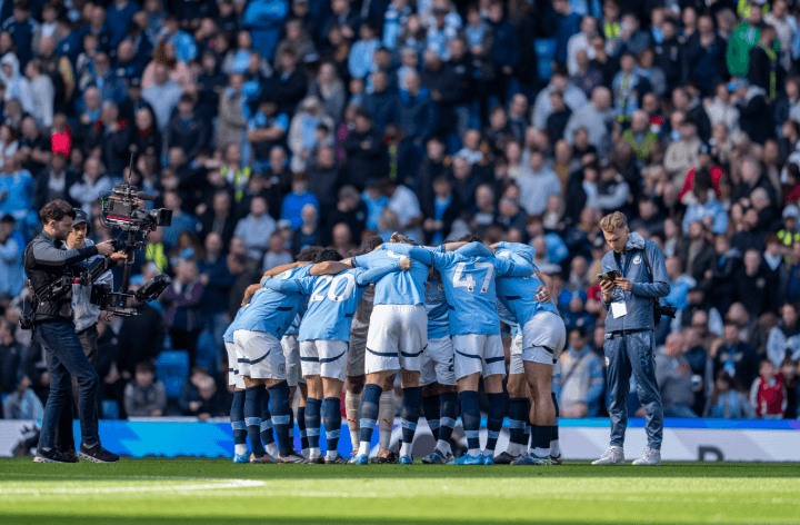 Manchester City players in a huddle before kick-off.
