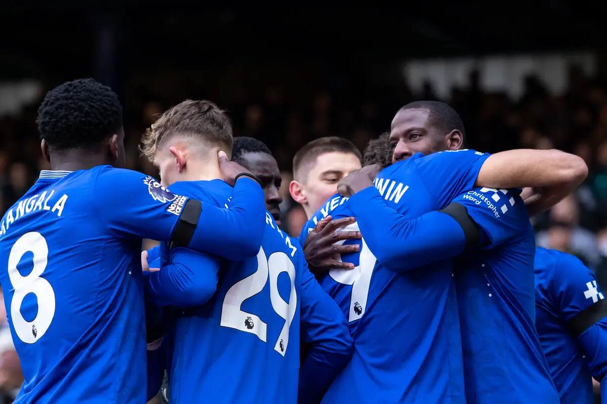 Everton players hugging and celebrating together.