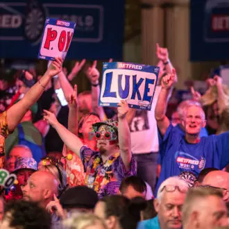 Fans holding up signs for their favourite darts stars at the World Matchplay Darts in Blackpool.