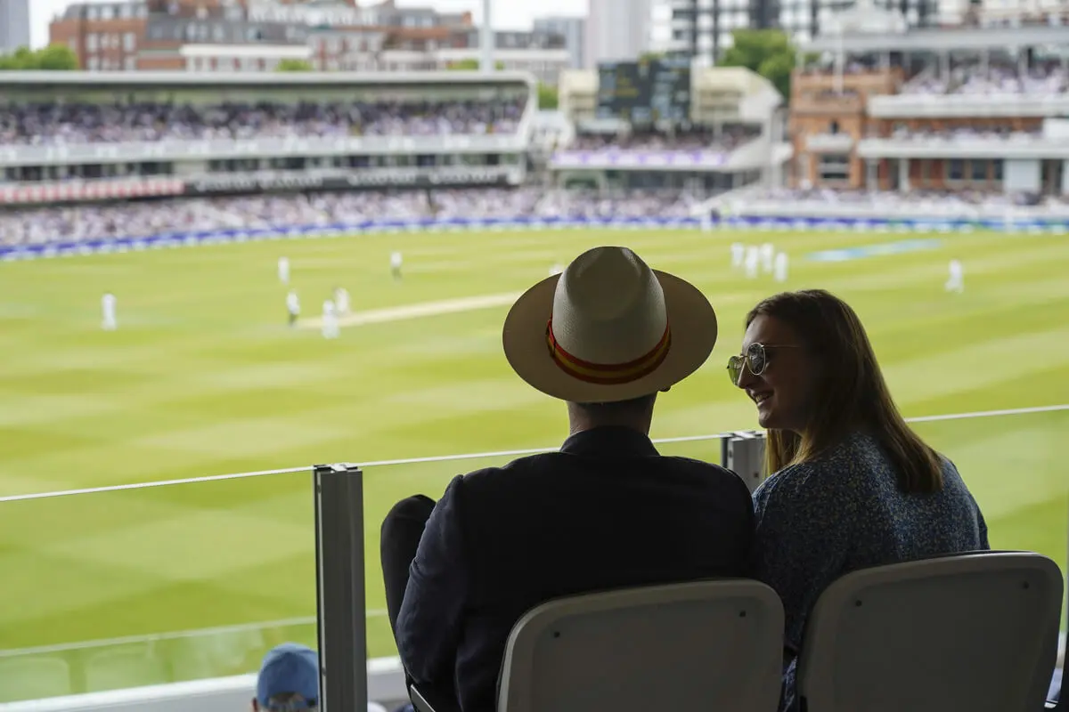 Couple enjoying the view across the wicket at Lord's Cricket Ground, London.