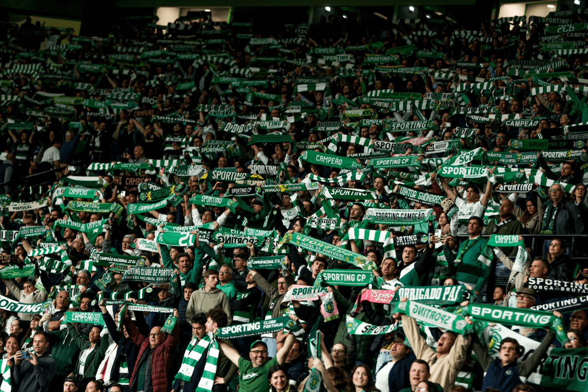 Sporting CP fans lifting their green and white scarves in the air.