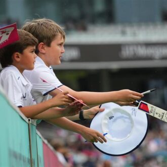 Children with signed merchandise from players at Lord's Cricket Ground.